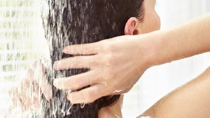 une femme se lave les cheveux
