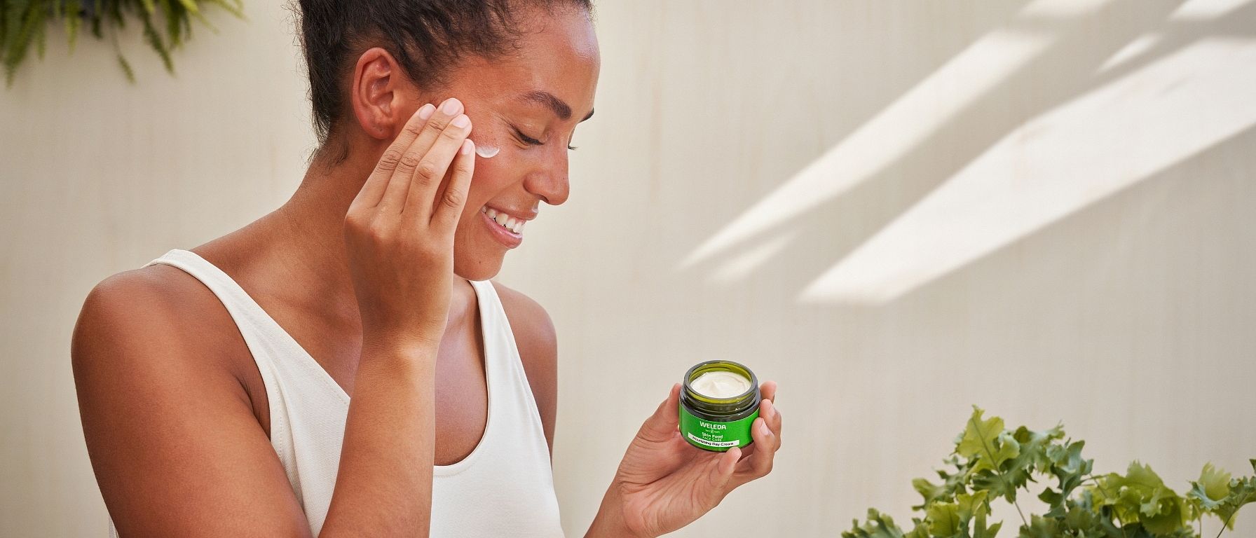 Vrouw doet Skin Food Voedende dagcrème op
