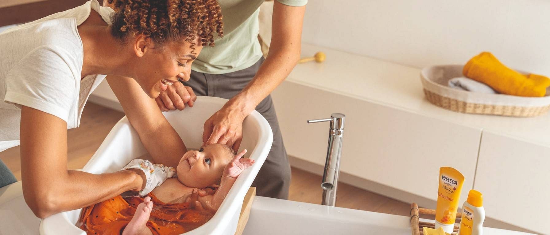 Une mère baigne son bébé avec Weleda