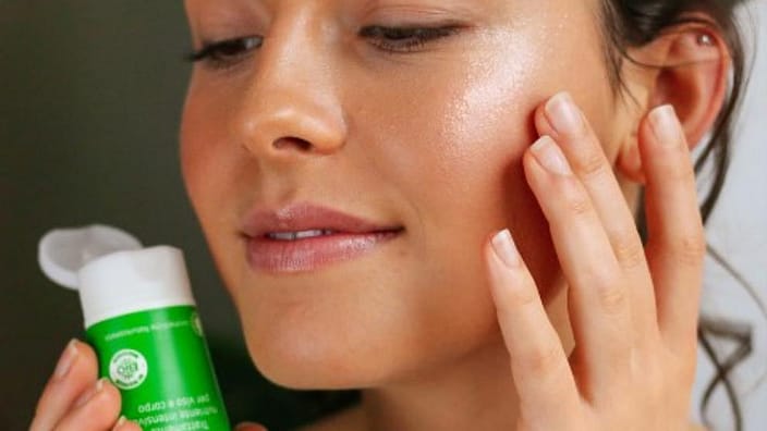 Une femme s'enduit le visage de Skin Food