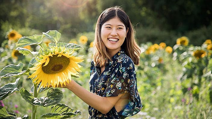 Une femme tient un tournesol