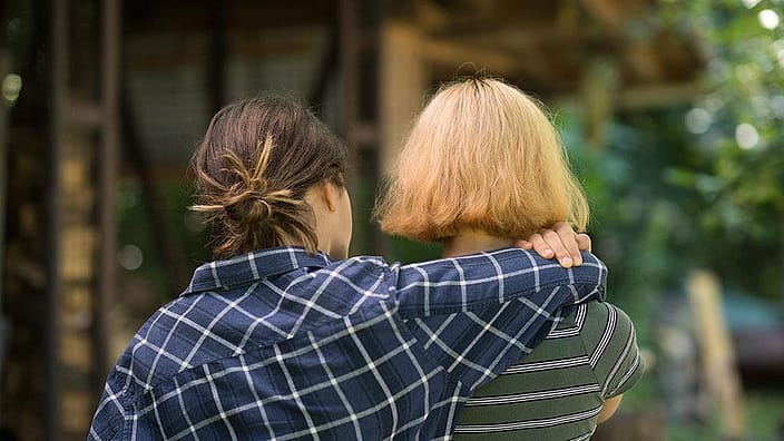 Une femme passe son bras autour d'une autre femme.