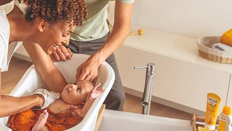 Moeder doet haar baby in bad met Weleda