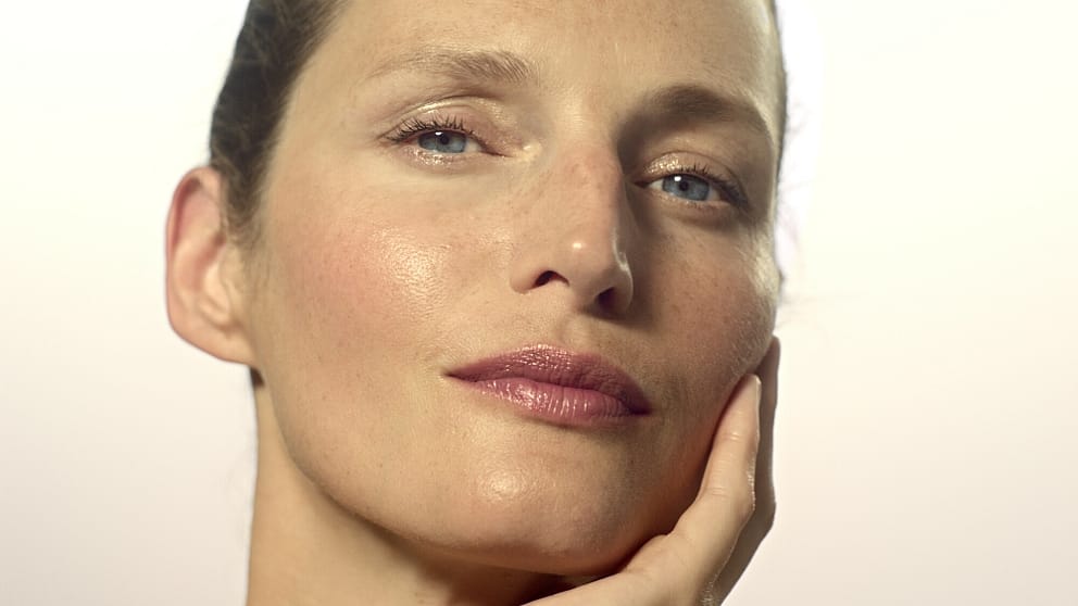 Une femme s'enduit le visage de crème de nuit